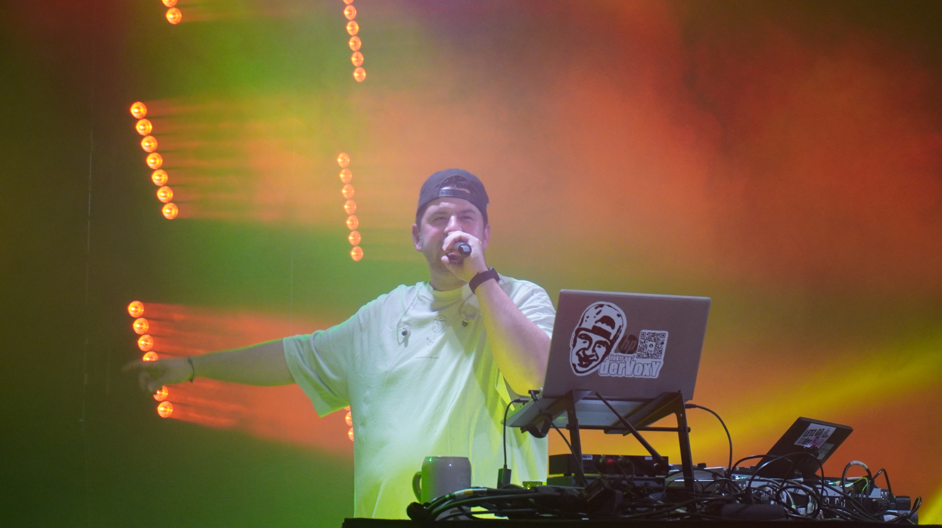 DJ Voxy live mit Mikrofon und Bühnenlicht